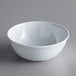 An Acopa Foundations white melamine bowl on a gray surface.