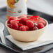 An Acopa Foundations melamine bowl filled with raspberries and strawberries on a table.