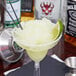 A Fineline plastic margarita with a clear base and a lime wedge.
