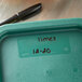 A green Vigor polypropylene food storage container lid on a green container with a label.