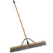 A Rubbermaid commercial broom with a wooden handle.