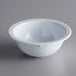 A white bowl with a white rim on a white surface.