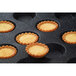 A Sasa Demarle Flexipan tray with 60 mini tartlets in it.