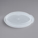 A translucent plastic lid for a round container on a white surface.