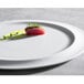 A piece of raw tuna with green sprigs on a Corona by GET Enterprises bright white porcelain plate.