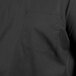 A close-up of a black Uncommon Chef cook shirt with a pocket.