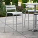 A white Lancaster Table & Seating outdoor bar stool on a patio table.