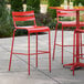 A red bar stool on a patio.