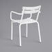 A white Lancaster Table & Seating outdoor arm chair with a metal frame and arms.