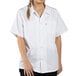 A woman wearing a white Uncommon Chef short sleeve cook shirt.