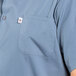 A person wearing a Uncommon Chef steel gray cook shirt with a pocket.