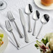 Acopa Sienna stainless steel spoon on a white tablecloth
