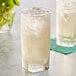 A glass of Boylan Ginger Ale with ice and a straw on a white background.