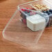 A clear Fabri-Kal plastic deli container filled with yogurt, berries, and granola.
