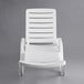 A white plastic Lancaster Table & Seating chaise lounge.