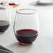 Two Anchor Hocking Vienna stemless red wine glasses filled with red wine on a table.