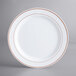 A white plastic plate with rose gold bands.