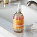 A bottle of Seventh Generation Mandarin Orange & Grapefruit liquid hand soap with a white lid on a counter.