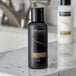 Two black bottles of TRESemme Luxurious Moisture Shampoo on a counter.