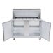 A stainless steel Traulsen refrigerated counter with open left and right hinged doors.