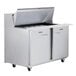 A Traulsen stainless steel sandwich prep table with one left hinged and one right hinged door open.
