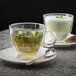 Two Villeroy & Boch glass cups of tea with mint leaves on saucers.