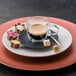 A Villeroy & Boch Artesano Barista double wall glass cup with a brown liquid on a saucer.
