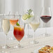 Acopa Elevation wine glasses filled with white and red wine on a table with appetizers.
