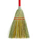 A close-up of a Carlisle lobby corn broom with a red handle and yellow bristles.