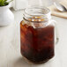 A mason jar filled with Crown Beverages cold brew coffee on a table.