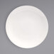 A Front of the House European white porcelain plate with a white rim on a gray surface.