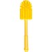 A yellow Carlisle Sparta cleaning brush with a handle and round bristles.
