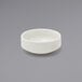 A Front of the House European white porcelain ramekin on a gray surface.
