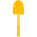 A Carlisle yellow plastic brush with long, round bristles.