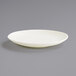 A Front of the House European White porcelain plate with a small rim on a gray surface.