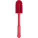 A close-up of a red Carlisle Sparta cleaning brush with a handle.