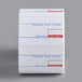 A roll of white Cardinal Detecto labels with red and blue print.