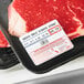 A piece of meat in a black tray with a Cardinal Detecto safe handling label.