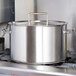 A large silver Vollrath sauce pot on a stove.