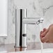 A hand washing under a Waterloo hands-free faucet.