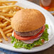 A close-up of a burger and fries on a plate with Udi's gluten-free hamburger bun.