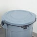A Rubbermaid gray plastic lid on a gray Brute trash can.