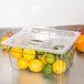 A Cambro clear plastic food pan filled with lemons and limes.