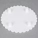 A white round Wilton cake separator plate with scalloped edges and holes in it.