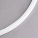 A white plastic gasket for a Carlisle Cateraide on a gray surface.