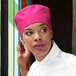 A woman wearing an Epic Berry chef skull cap with a pink and white design.