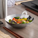 A Vollrath mini wok filled with vegetables on a table.