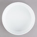 An Arcoroc white porcelain stackable bowl on a gray surface.