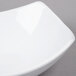An American Metalcraft square stoneware bowl with a curved edge on a gray surface.