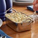 A rectangular stainless steel roasting pan with macaroni and cheese in it.